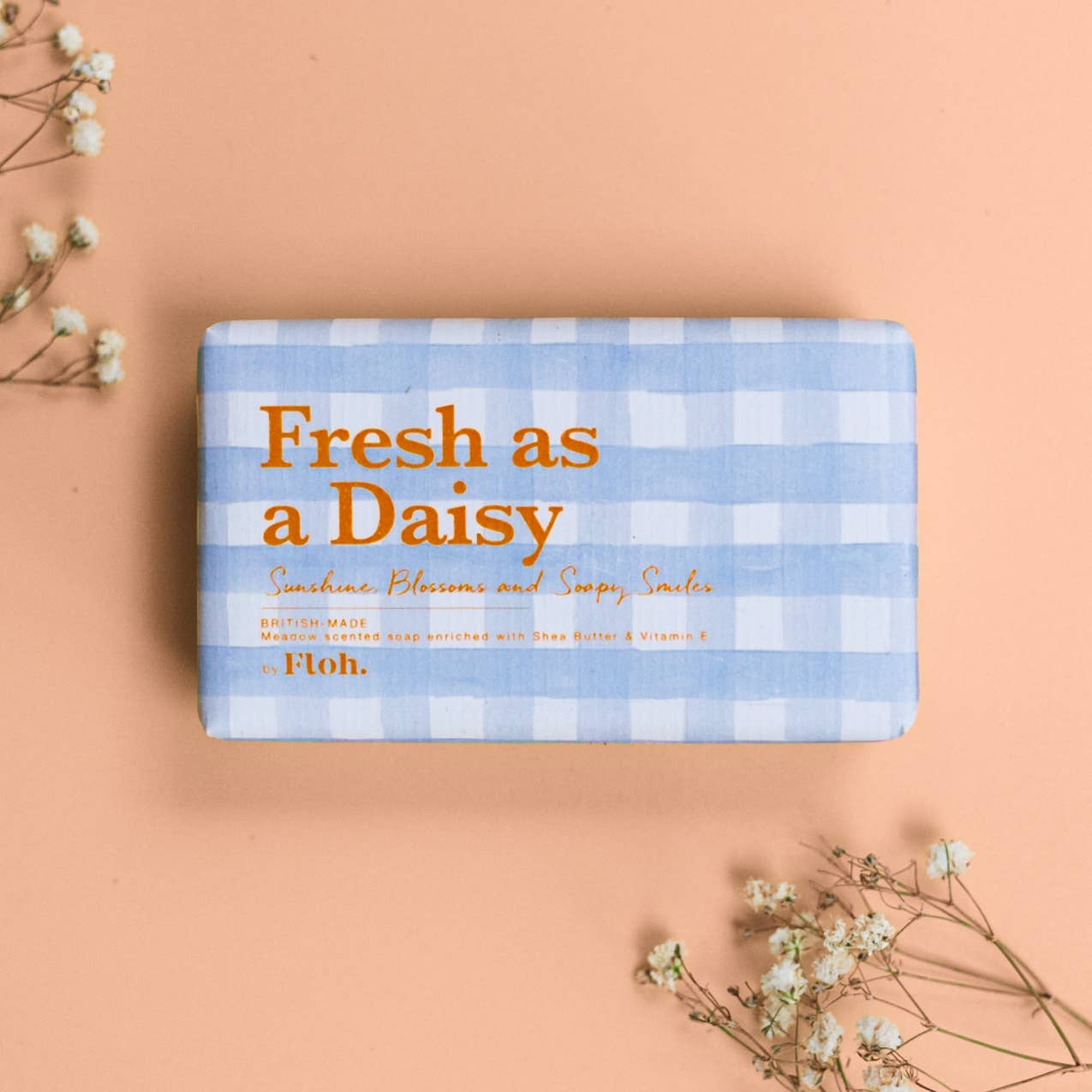 Toasted Crumpet Fresh as a Daisy 190g soap bar in blue gingham wrap with dried flowers on a soft peach background