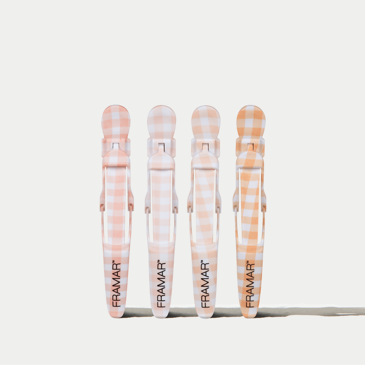 Four Framar Peach Please Gator Grips in peach gingham on a white background