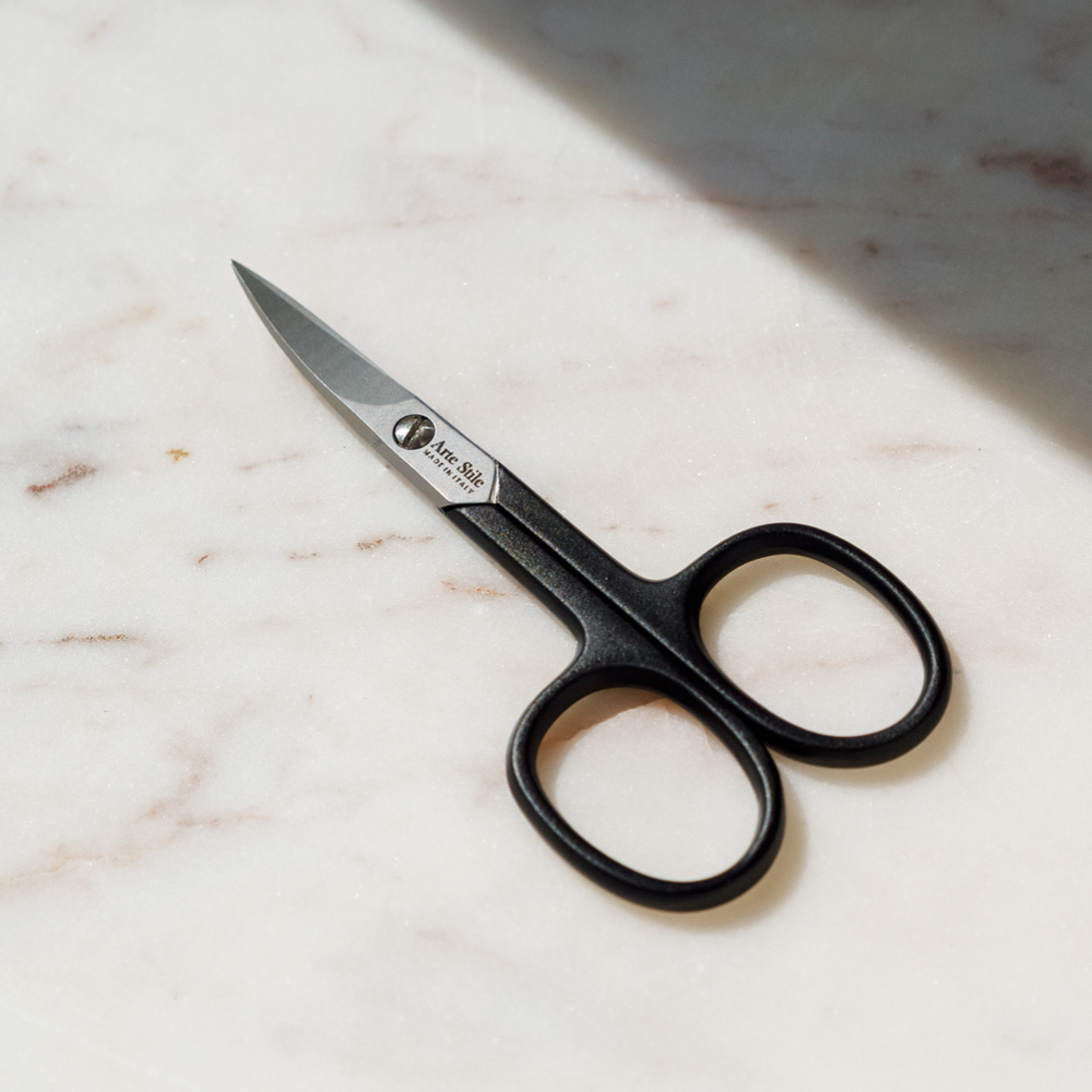 ArteStile Nail Scissors in Matte Black in use, trimming a natural nail