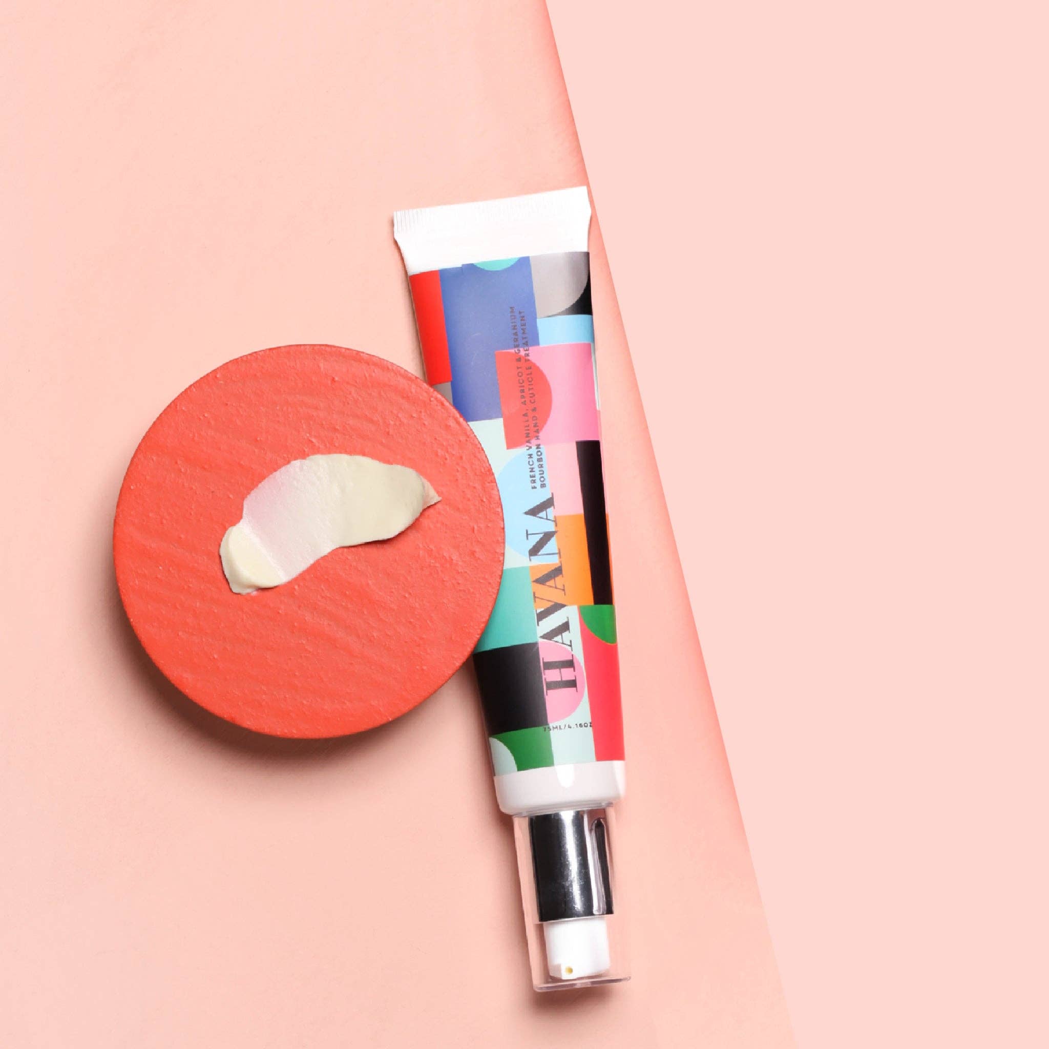 Dan300 Hand & Nail Treatment tube with colourful packaging and a red disc with a sample swatch on a pink background