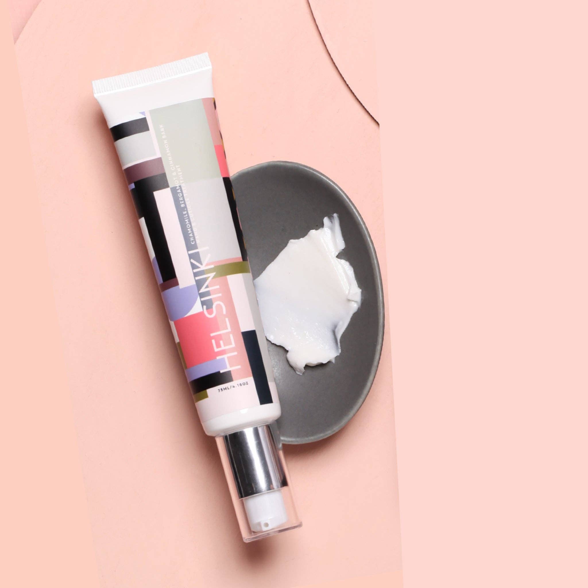 Dan300 Hand & Nail Treatment skincare tube with a sample swatch on a pink background