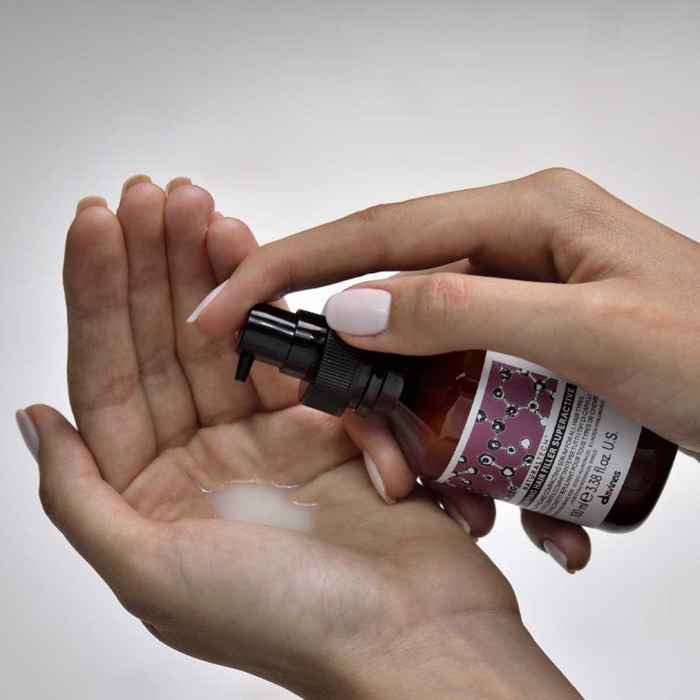 Davines Replumping Hair Filler Superactive dispensed into hand showing lightweight leave-in texture
