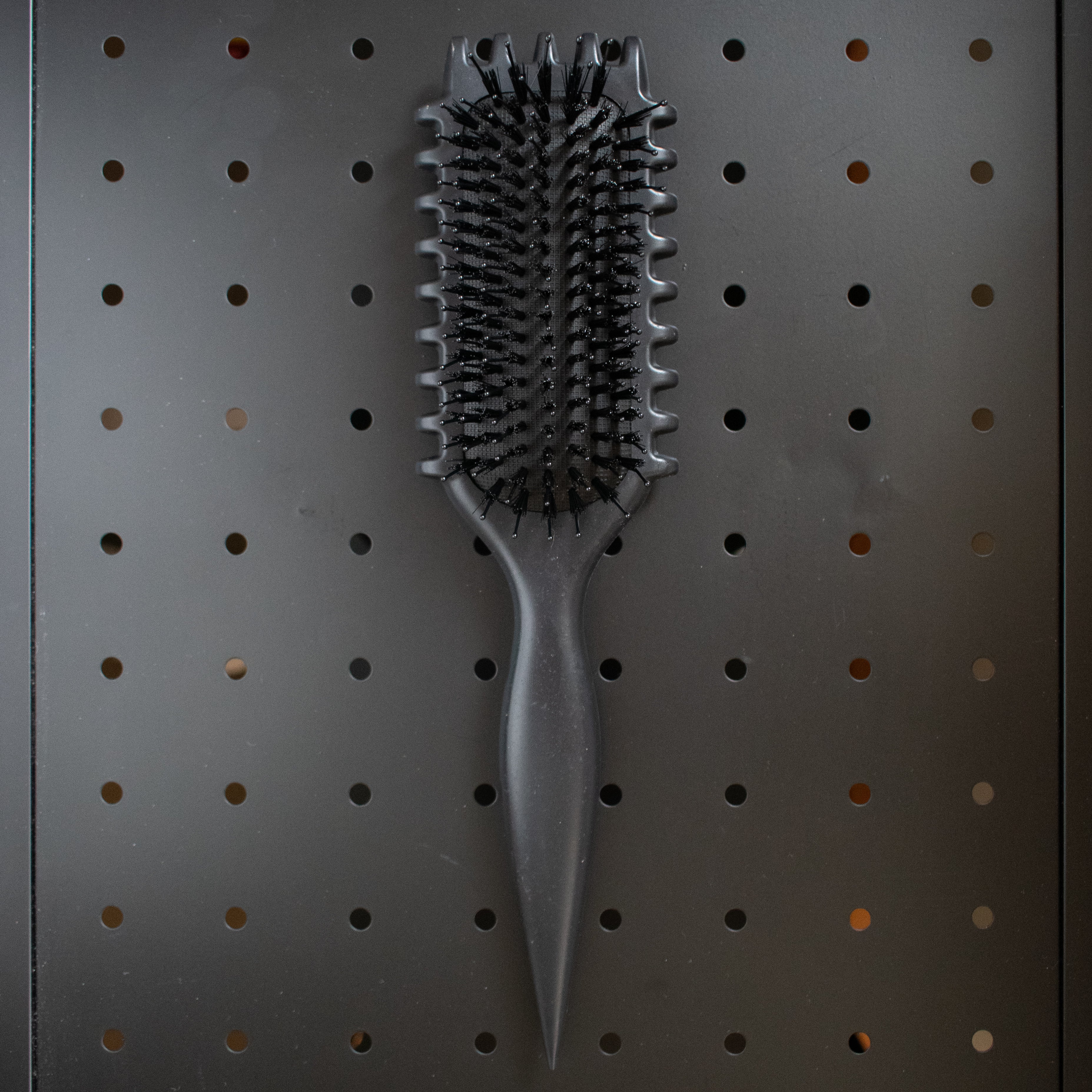 black curly girl Hairbrush on a pegboard