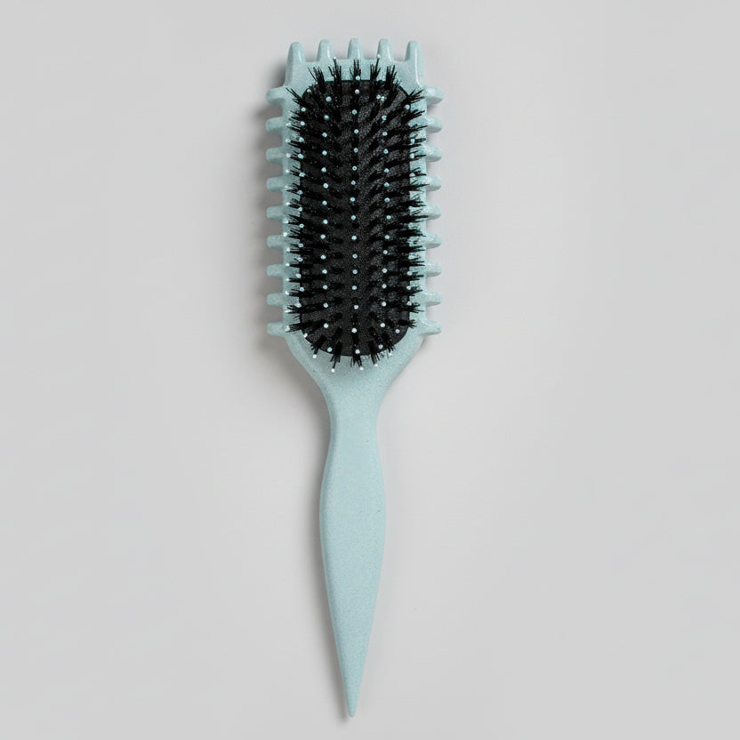 Blue curly girl hairbrush with black bristles on a pegboard background