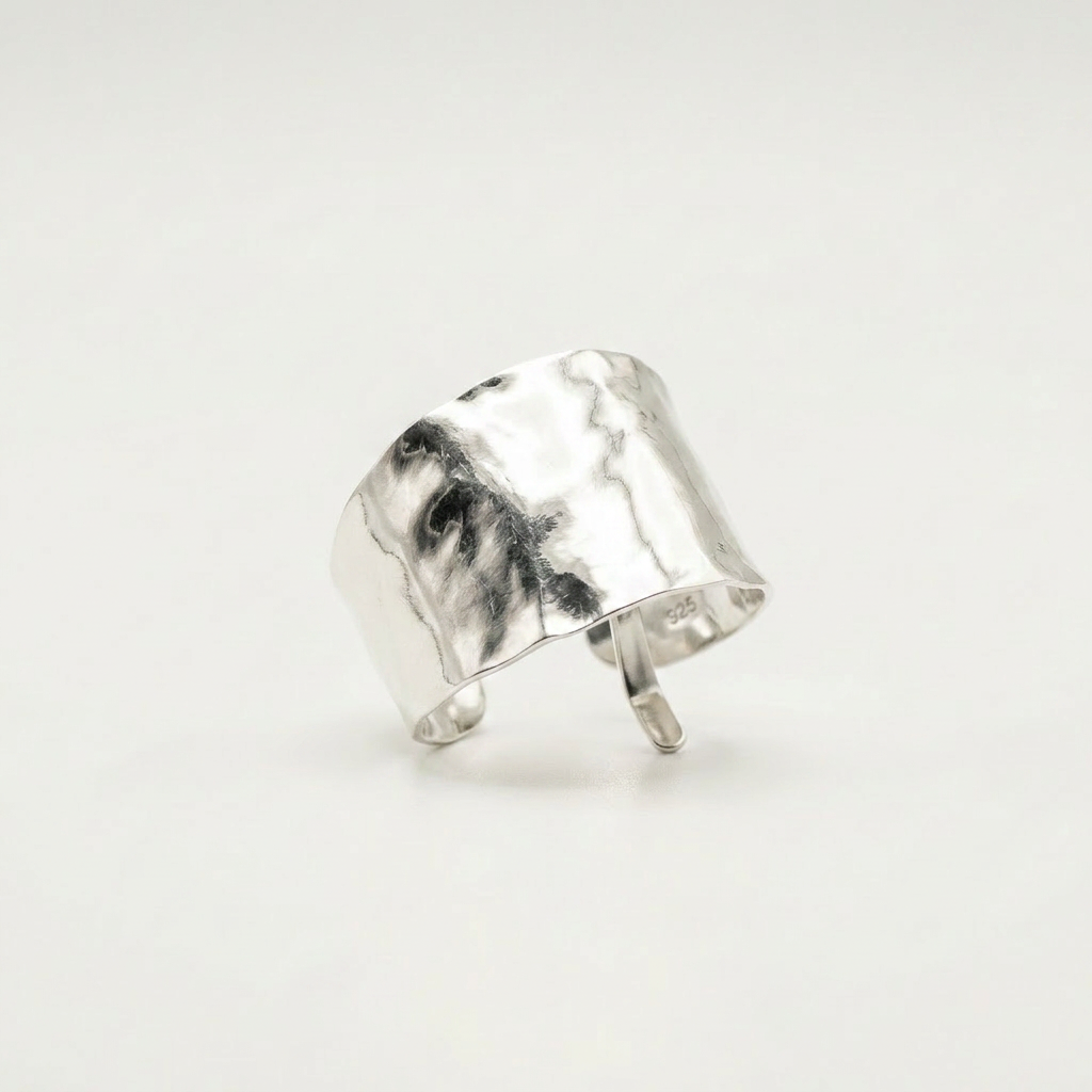 Silver ponytail cuff with a textured surface on a light gray background