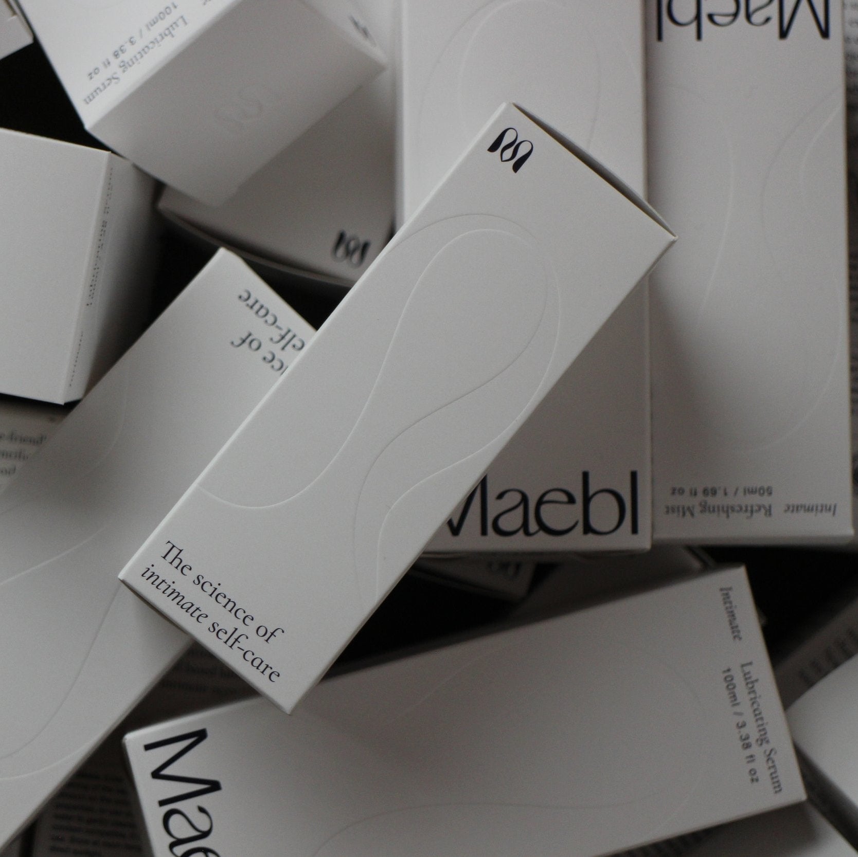 Pile of white boxes with 'Maebl' branding on a dark background