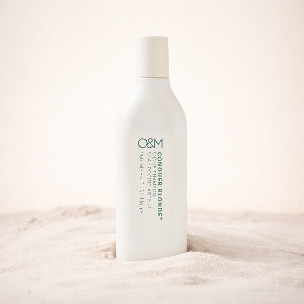 White shampoo bottle with 'O&M' branding on a beige background