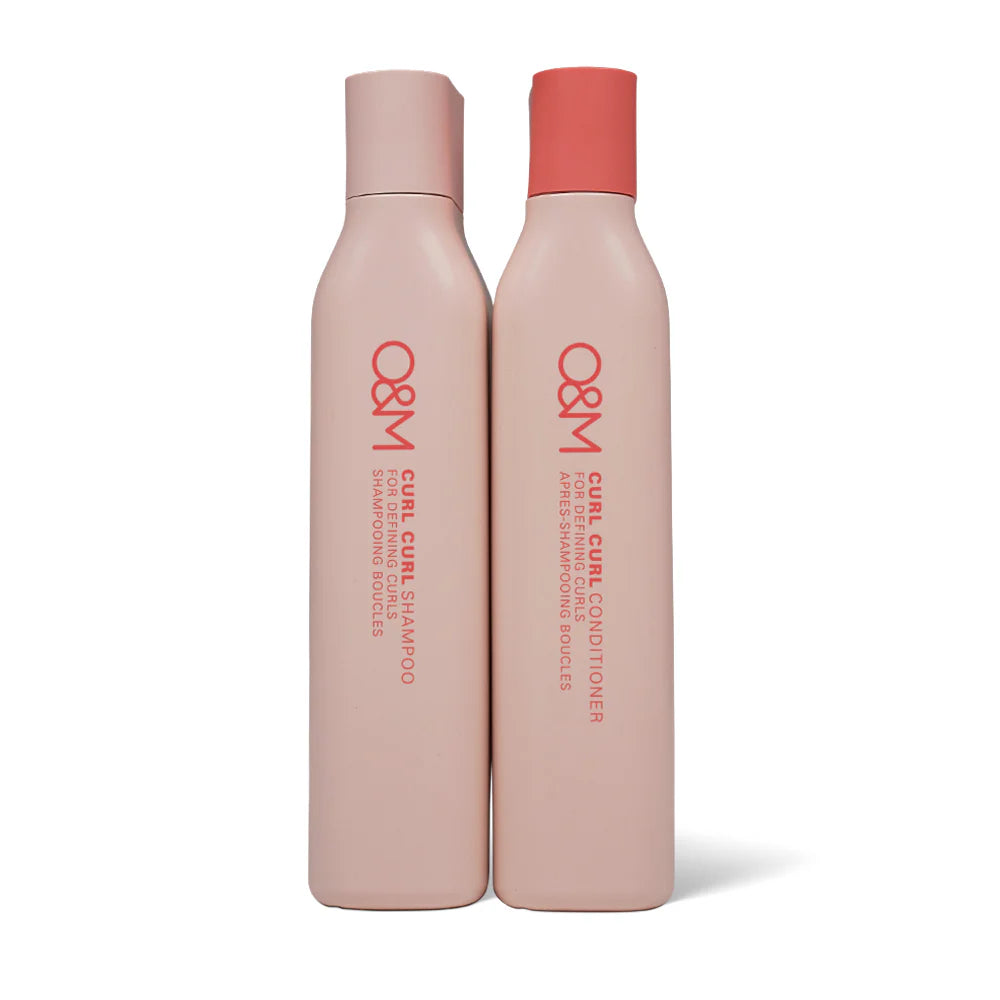 Two bottles of O&M Curl Curl Shampoo and Conditioner on a white background