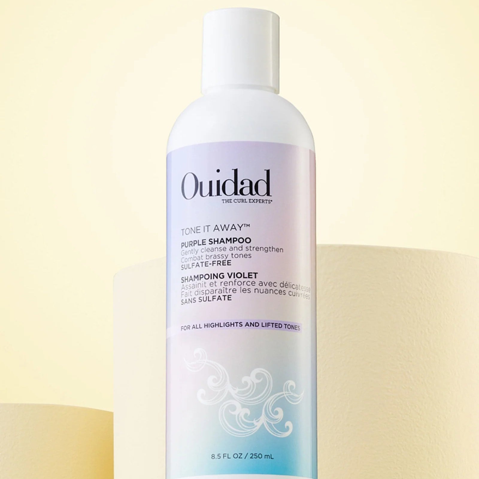 Ouidad Tone It Away purple shampoo bottle on a light background