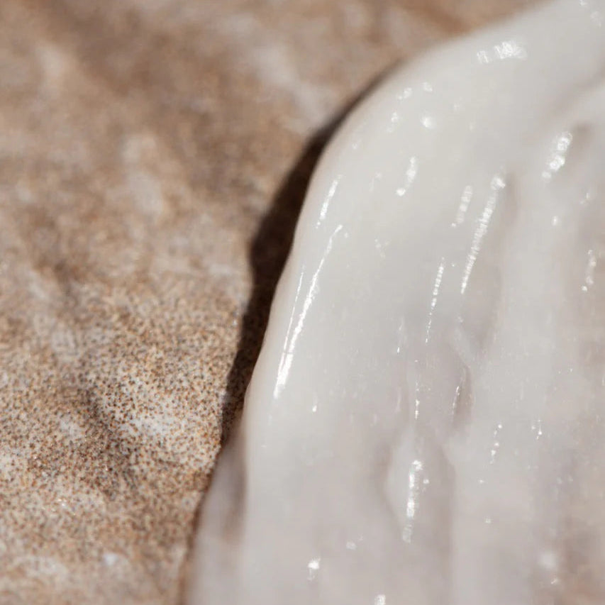 Close-up of a Rebuilding Hair Mask on sandy beach