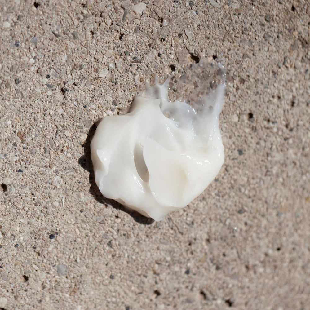 Oway Softening Shave cream swatch on a textured concrete surface