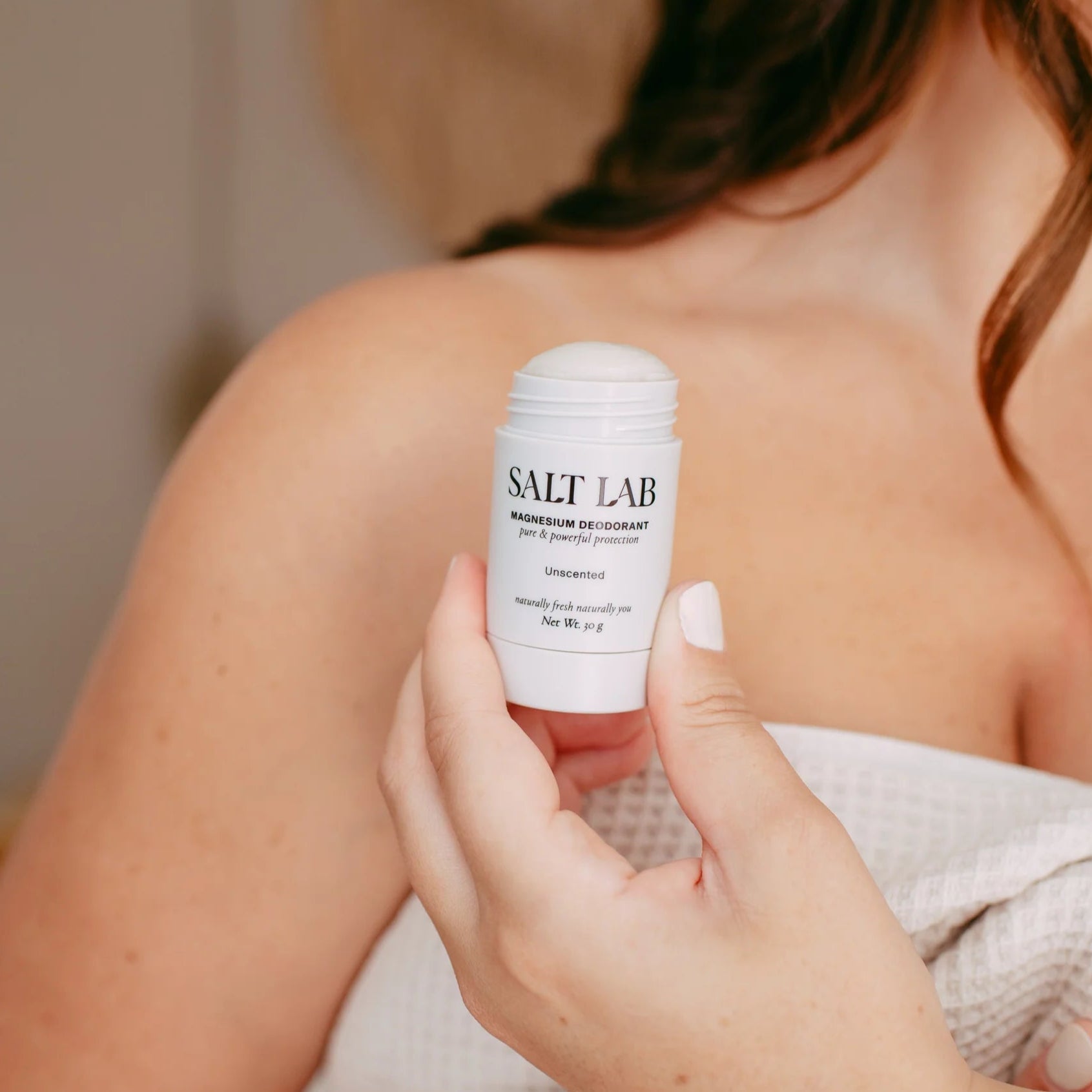 Person holding a 'Salt Lab' product on a blurred background