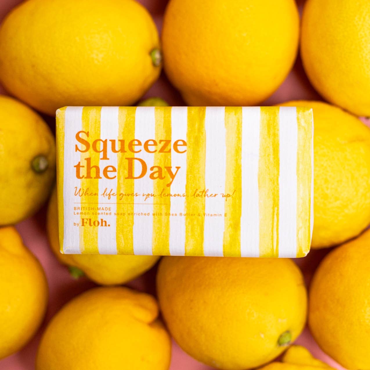 Toasted Crumpet Squeeze the Day 190g lemon soap bar in yellow striped wrap on a bed of lemons