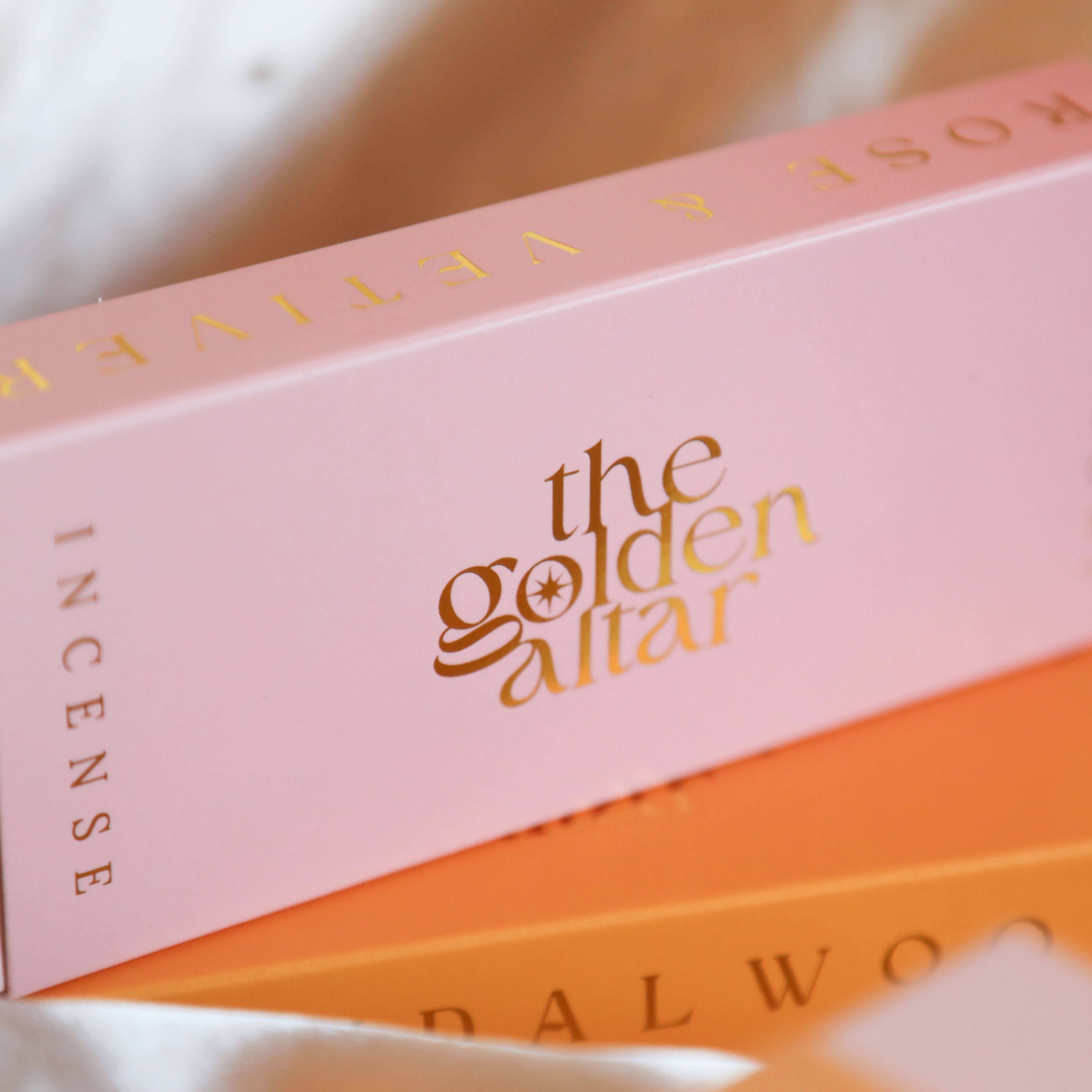 Pink box of 'the golden altar' incense with gold text on a white background