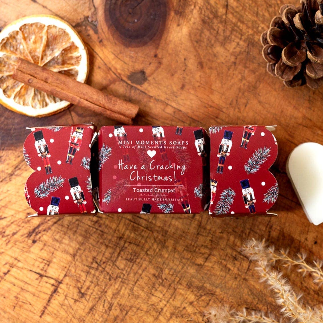 Toasted Crumpet Nutcracker cracker shaped gift box of three mini soaps on a rustic wooden table with dried orange and cinnamon