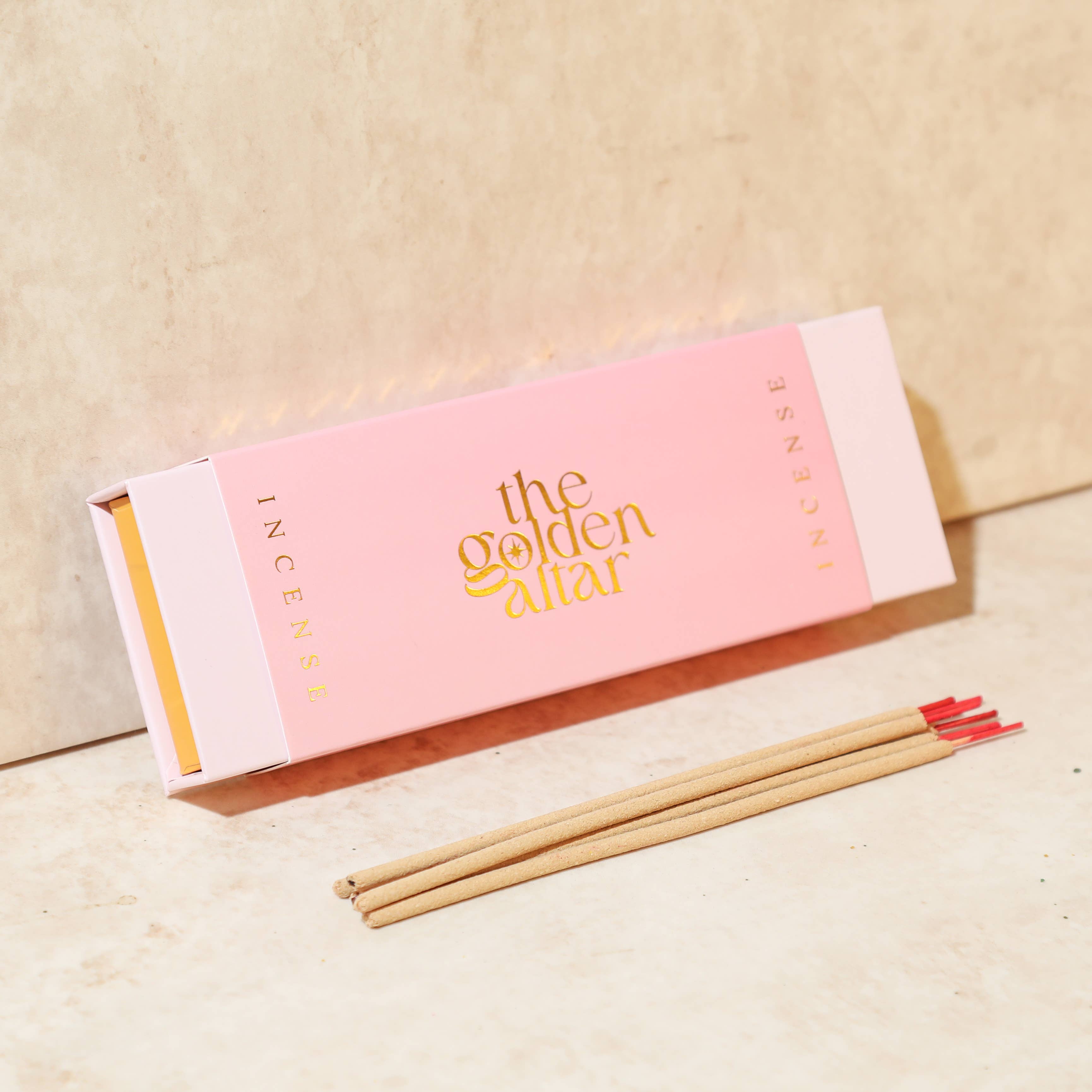 Incense sticks with pink packaging labeled 'the Golden Altar' on a beige background