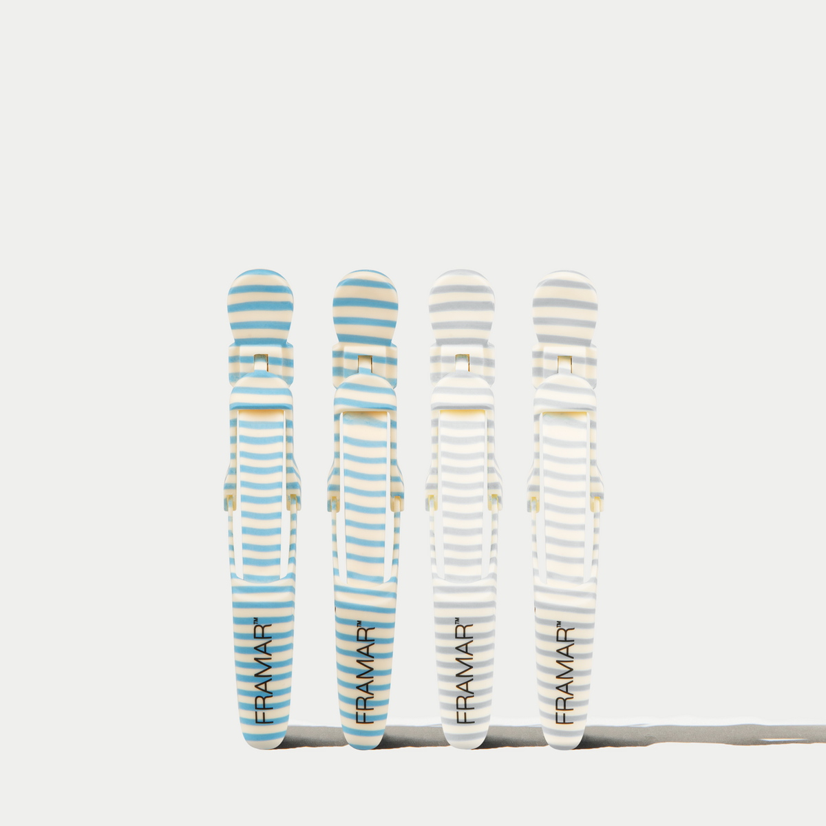 Four Framar Beach Bum Gator Grips in blue and cream stripes on a white background
