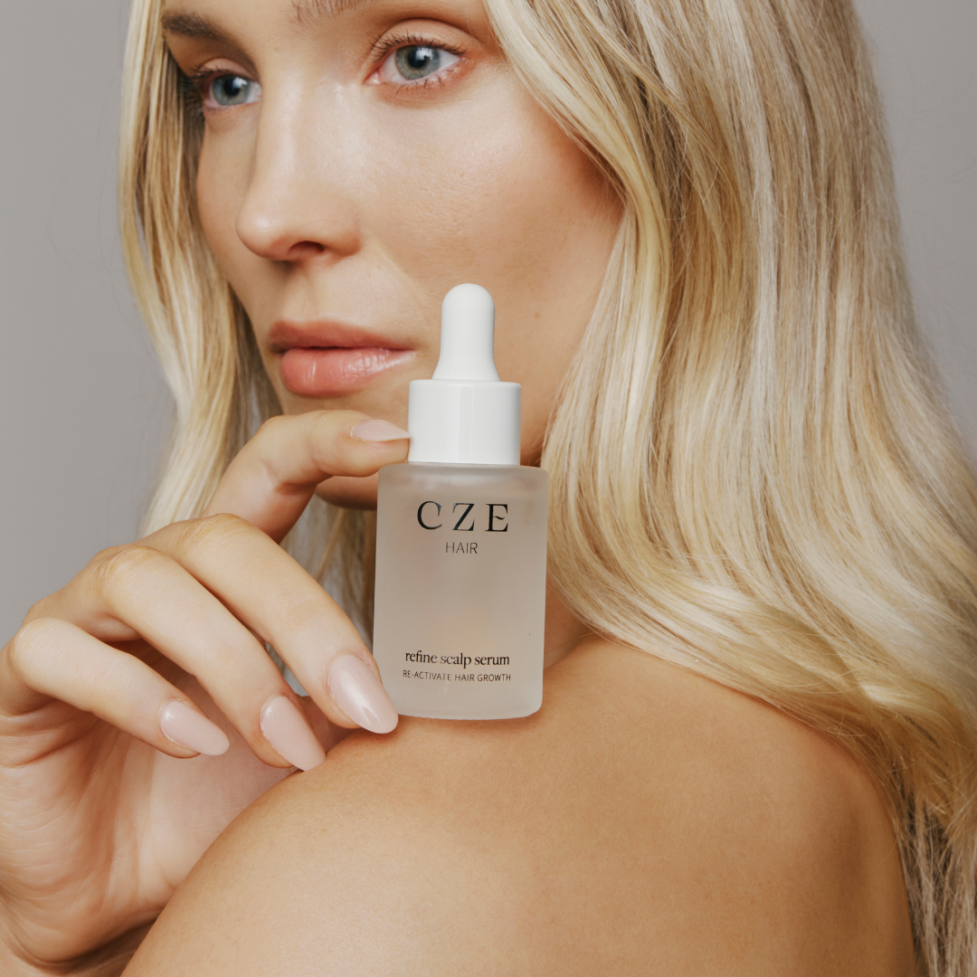 Model holding CZE Refine Scalp Serum dropper bottle for thinning hair