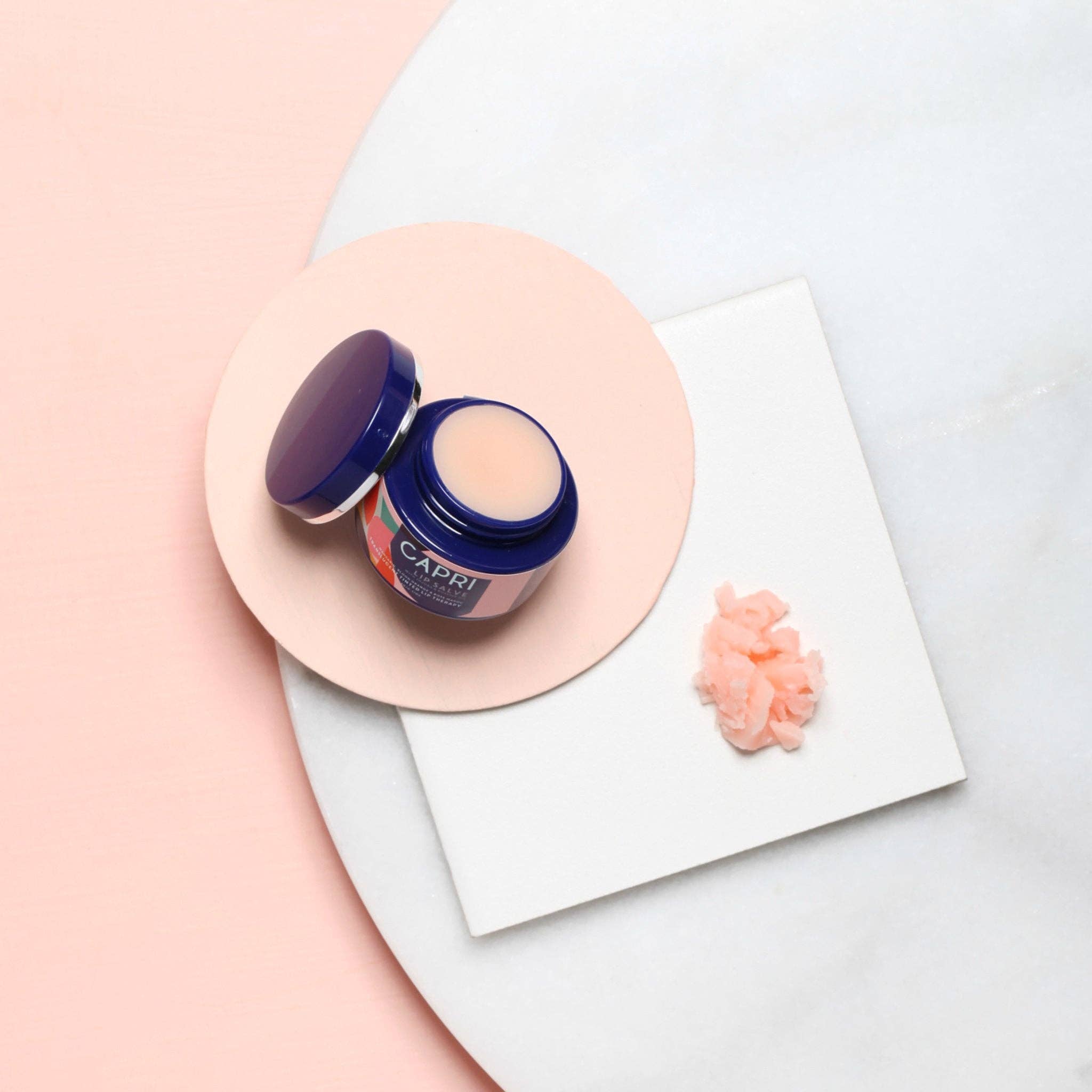 Dan300 lip balm container with a pink lid on a white and pink background