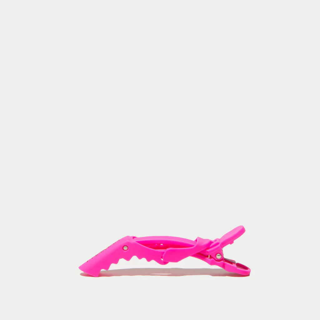 Pink hair clip on a light gray background