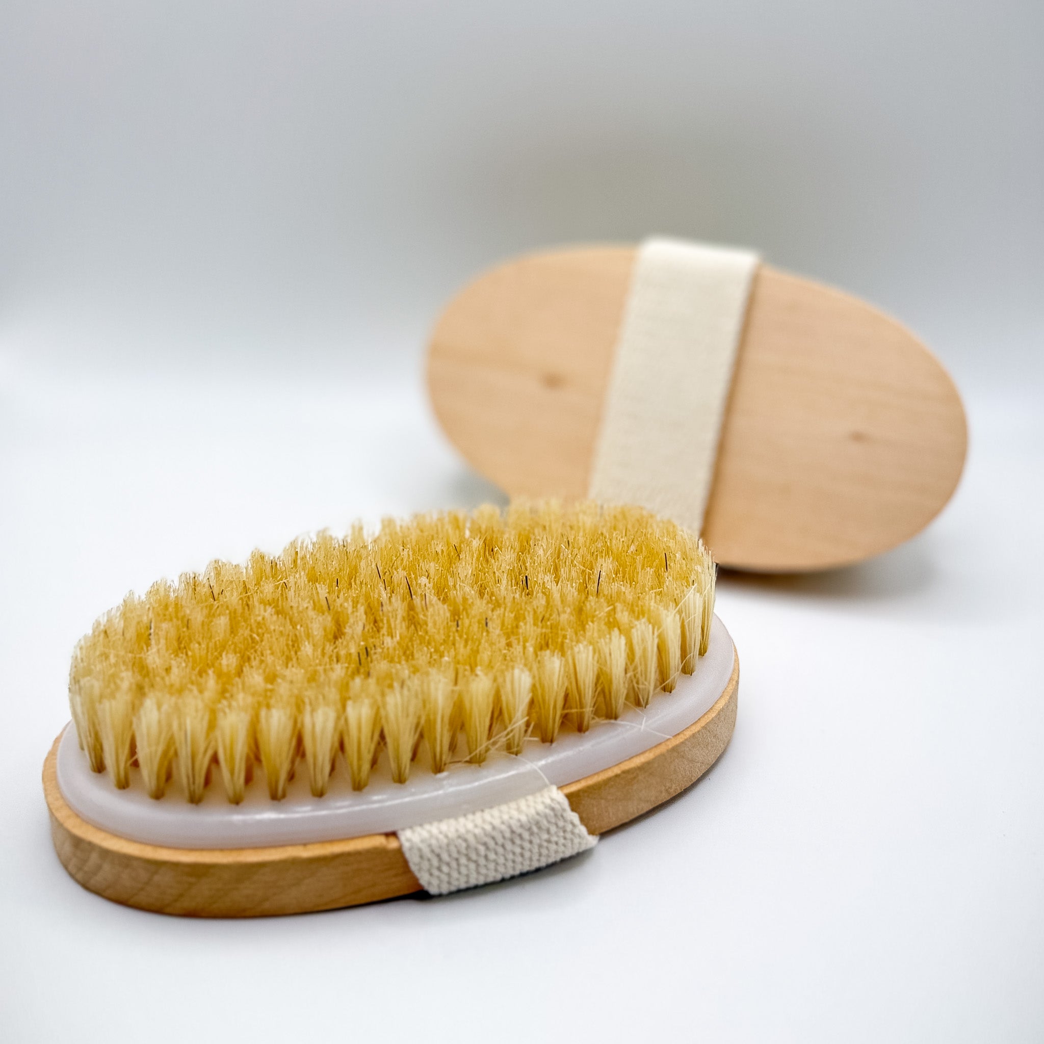 Body brush with natural bristles on a white background
