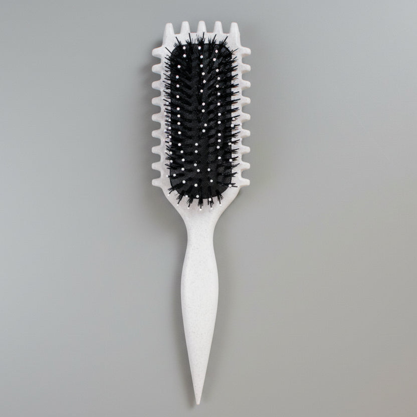 White curly girl hairbrush with black bristles on a pegboard background