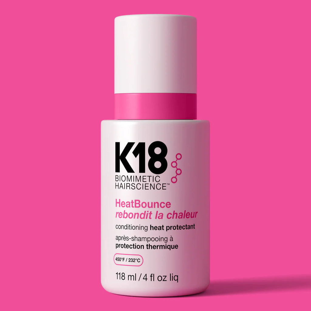 K18 HeatBounce hair product bottle on a pink background