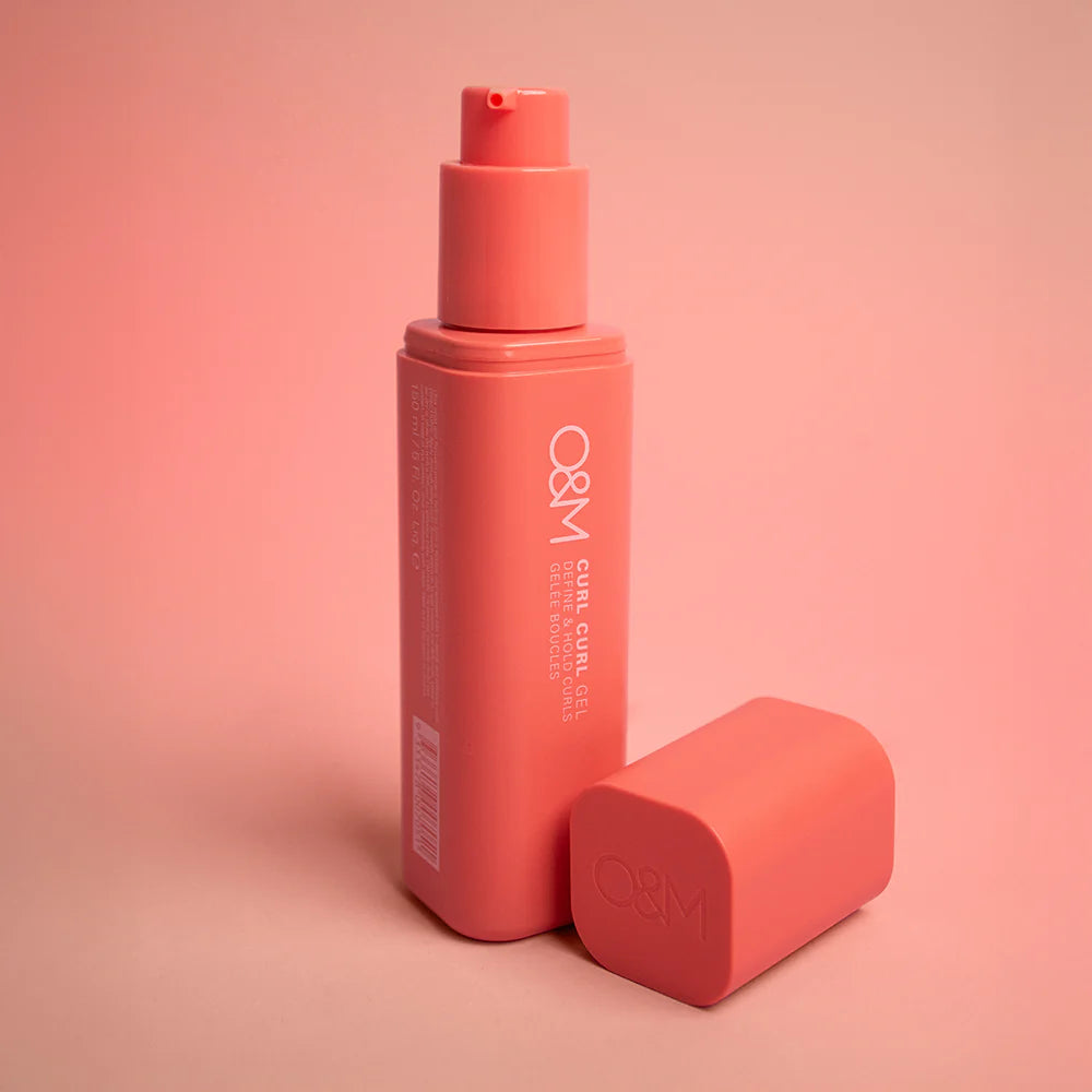Coral-colored bottle and cap with 'O&M Curl Curl Gel' branding on a pink background