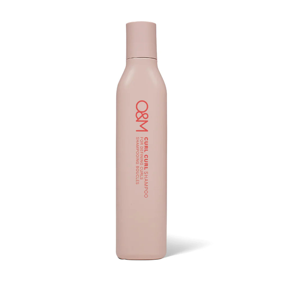Pink shampoo bottle with 'O&M Curl Curl Shampoo' branding on a white background