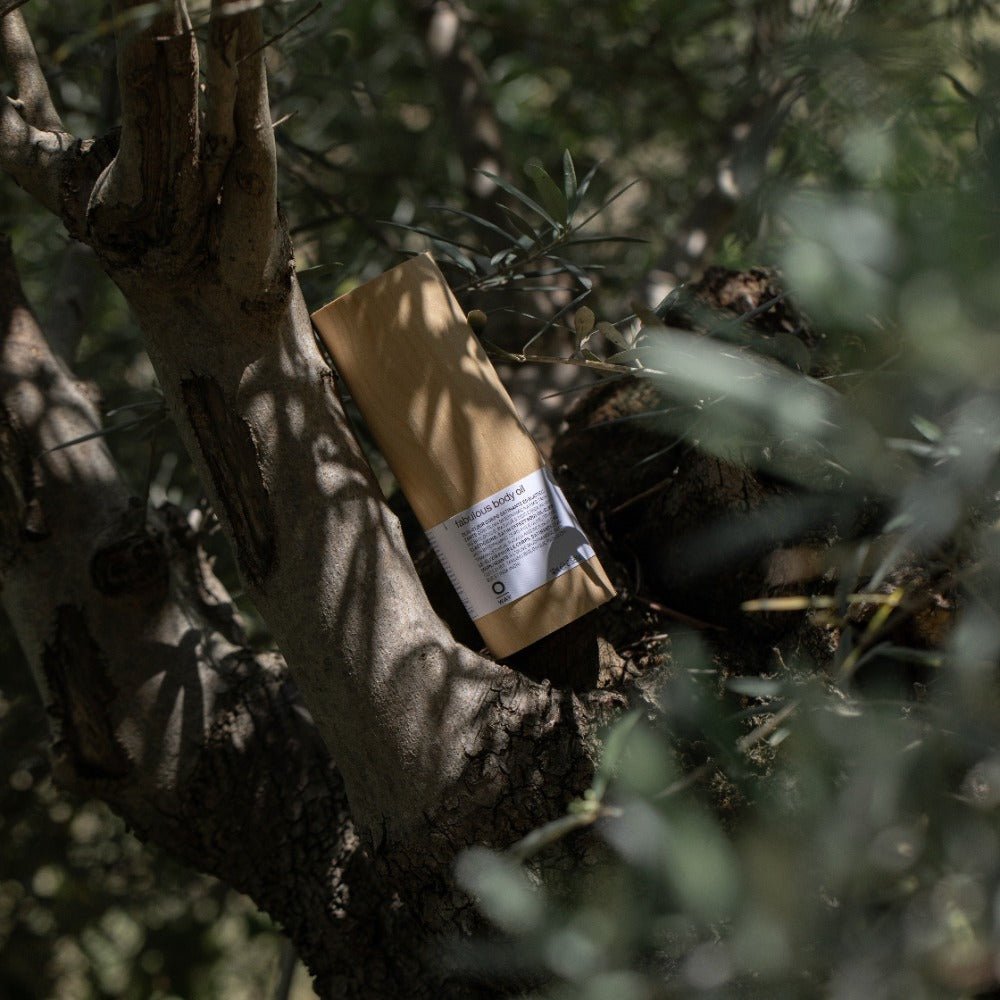 Oway Fabulous Body Oil bottle among greenery