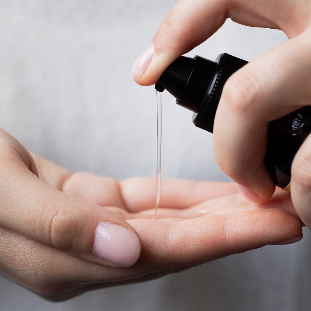 Oway Glossy Nectar Hair Oil being dispensed into hand
