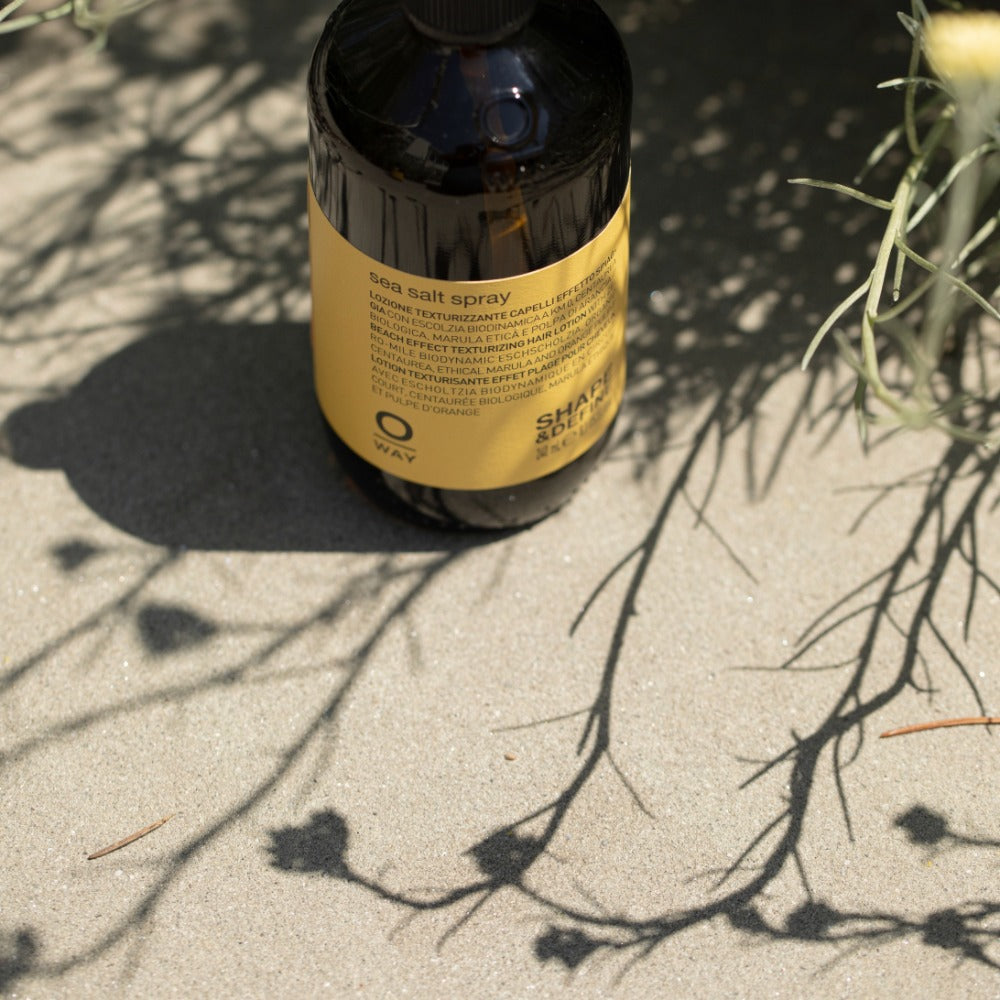 Oway Sea Salt Spray bottle amongst coastal beach grass