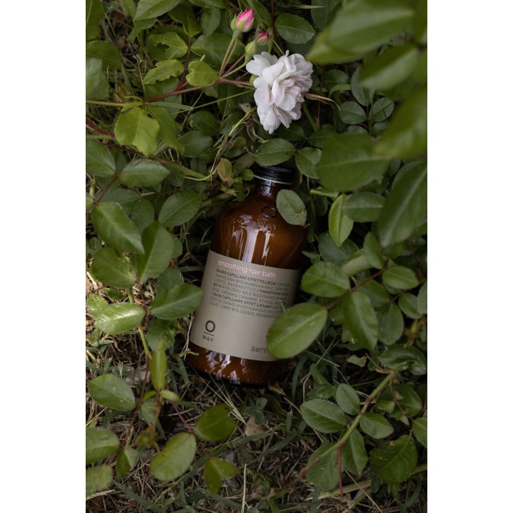 Oway Smoothing Hair Bath bottle amongst greenery