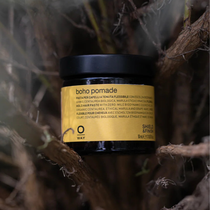 Jar of pomade with a gold label on a natural background