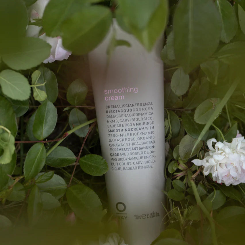 Oway Smoothing Cream Tube among green leaves and white flowers