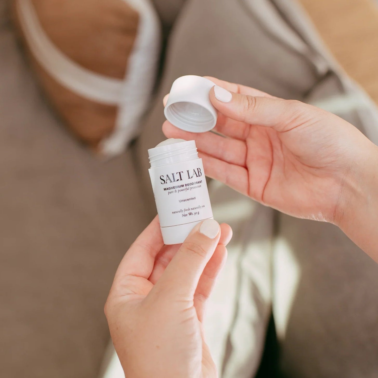 Person holding a small bottle labeled 'Salt Lab' with a blurred background