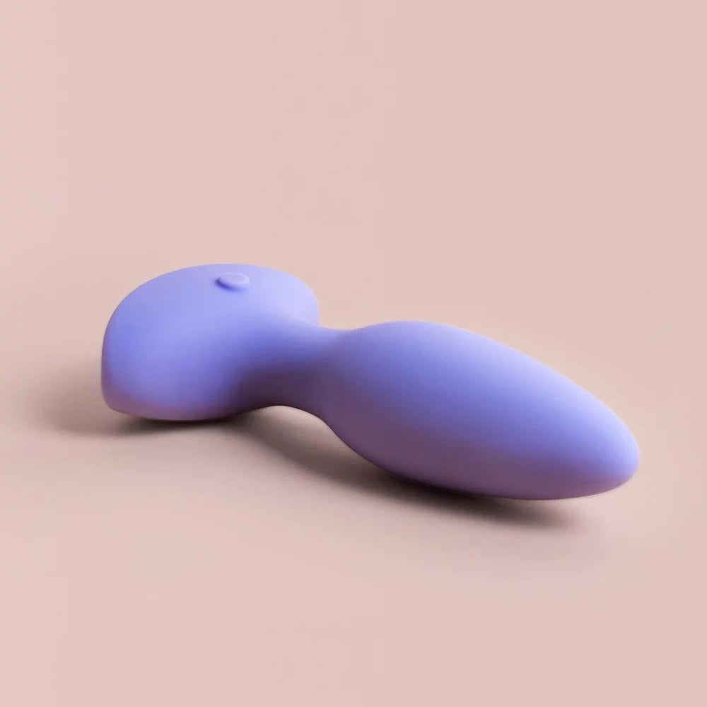 Purple silicone butt plug on a beige background