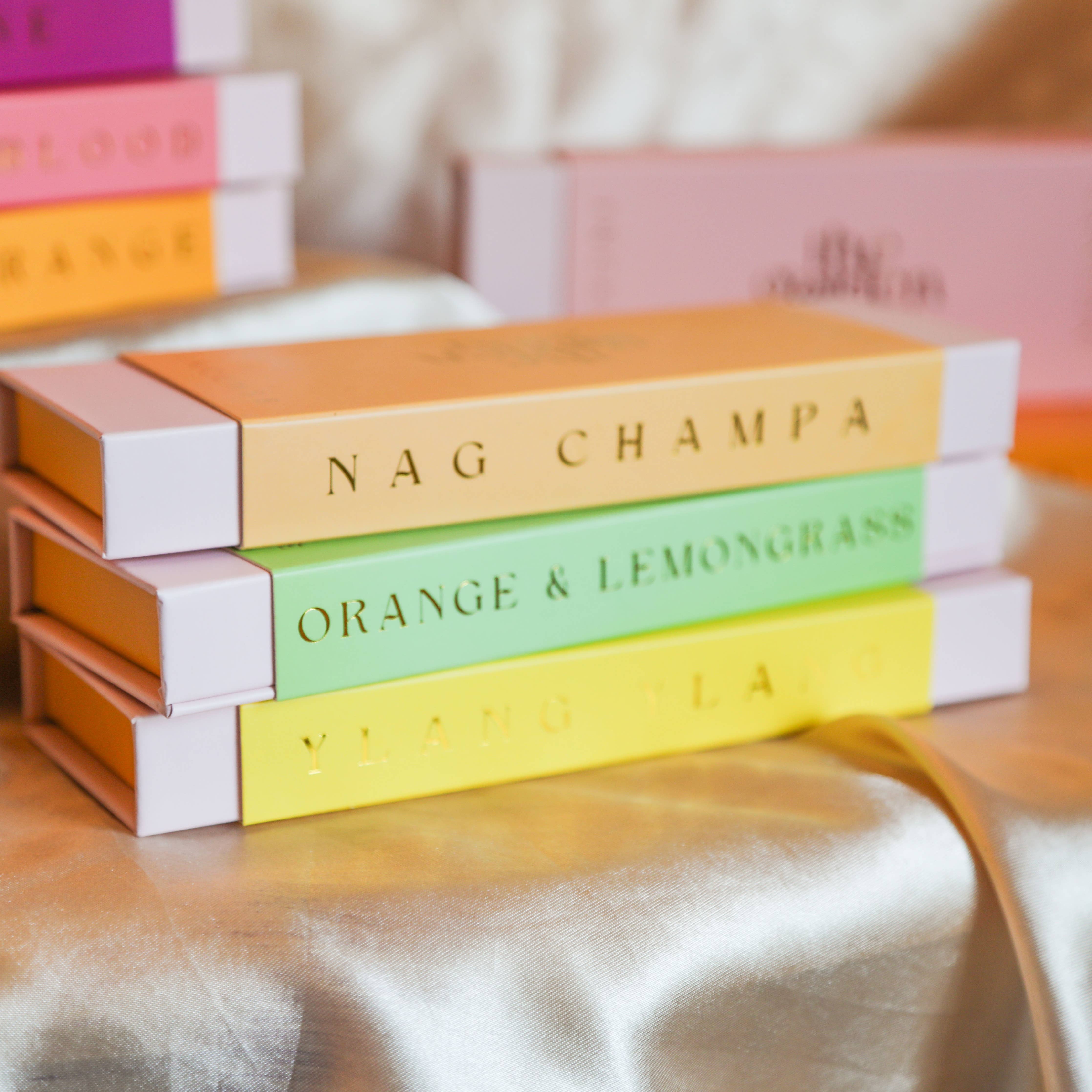 Stack of The Golden Altar colourful boxes with text on a soft fabric background