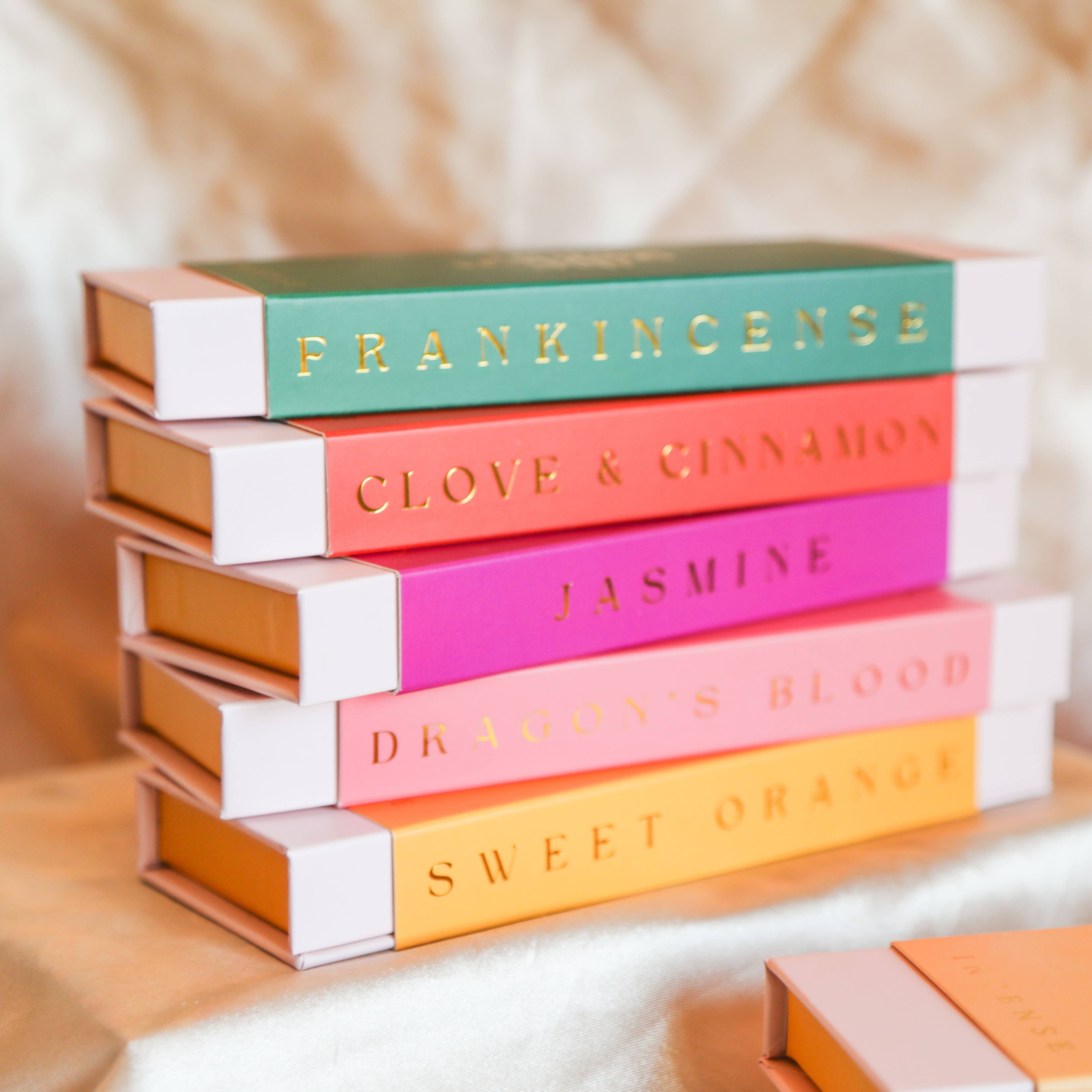 Stack of colourful The Golden Altar Incense sticks boxes on a soft, blurred background