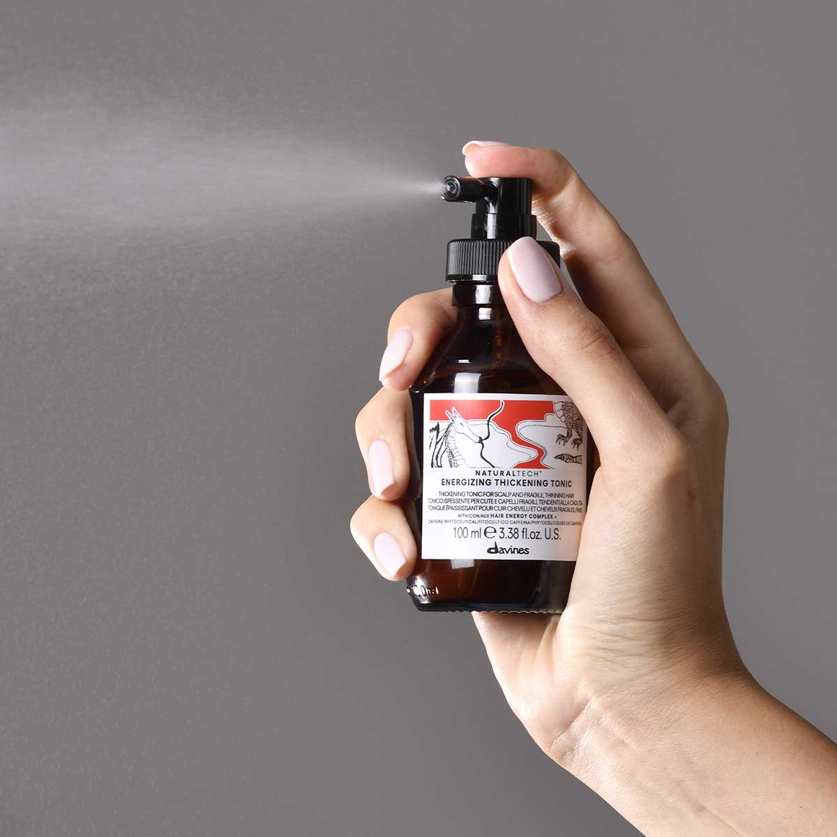 Davines Energizing Thickening Tonic spray applied to the scalp