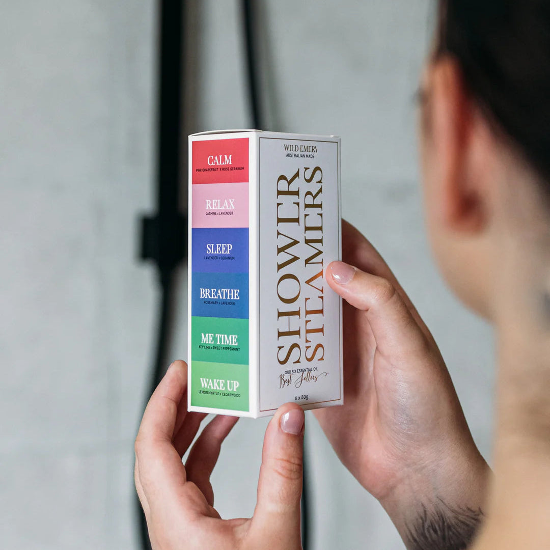 Person holding a box of Shower Steamers with various scents.