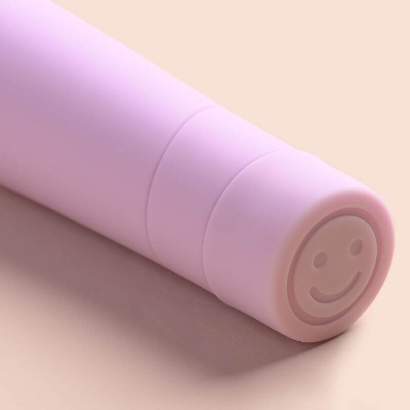 Close up of The Billionaire Vibrator brought to you by Smile Makers. Picture shows signature smiley face button on the base of the vibrator.